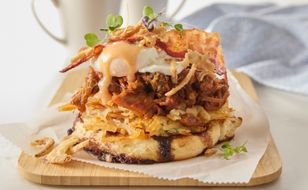 Smashed cinnamon roll sitting on a plate in a diner that specializes in breakfast foods